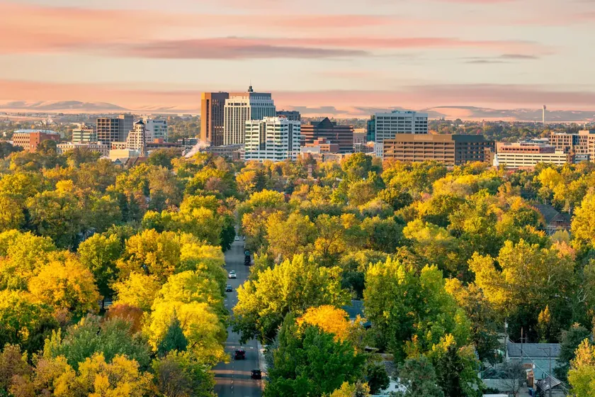 Downtown Boise skyline framed by autumn trees, with the Treasure Valley below.