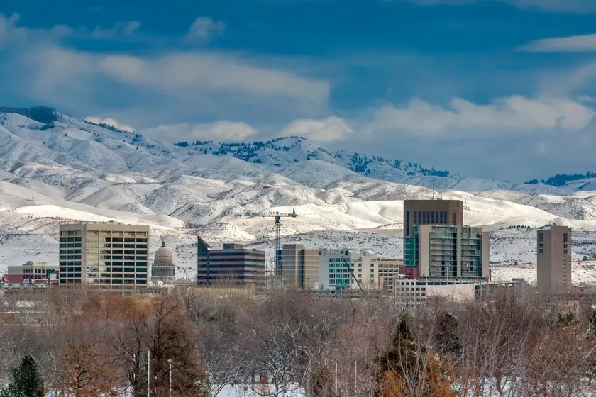 Downtown Boise and the Idaho State Capitol with snow-covered foothills in winter.